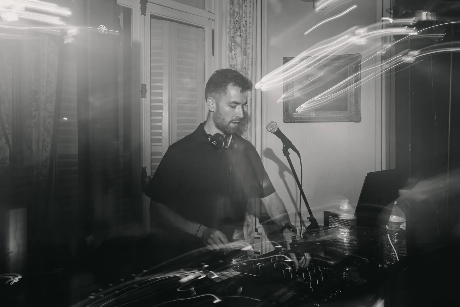 DJAY LEMON aux platines, casque autour du cou et micro à portée de main, dans une salle de réception.